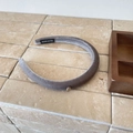 Detailed close-up of a grey velvet headband with a golden metal tag on a stone surface - Gray (D-4843-2)