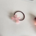 Detailansicht eines rosa Acryl-Haargummis mit braunem, hochelastischem Gummiband - Rosa Schleife (D-4013 -1)