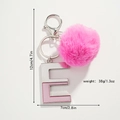 Portachiavi con pompon rosa e lettera E glitterata con moschettone in argento lucido - Lettera E Con Pompon Magenta