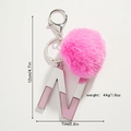 Vue détaillée d'un porte-clés lettre N rose pailleté avec pompon en peluche et dimensions - Lettre N