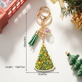 Weihnachtsbaum-Schlüsselanhänger mit Quaste und Glitzerkugel vor festlicher Deko - Weihnachtsbaum-Stil (Weihnachtsschlüsselanhänger)