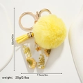 Detail view of yellow resin letter W keychain with floral inlay and soft plush pompom - Letter W Style (W)
