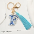 Detailed view of baroque blue and white pattern letter F keychain with silk tassel - Letter F