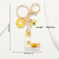 Détail du porte-clés lettre L en résine avec de vraies fleurs séchées jaunes - Style Lettre L