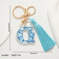 Detailed view of porcelain style letter Q keychain with blue silk tassel and pearl bead - Letter Q