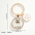 Close-up of golden dog keychain with American Bully image and pink paw charm detail - American Bully (KING BULLY)