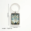 Detail view of a metallic wolf head keychain with blue eyes and bohemian art patterns - Blue Eye Bohemian Wolf Keychain (Style 5)