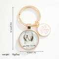Detailweergave van de hondenhanger sleutelhanger met glazen hanger en roze pootje - Bearded Collie