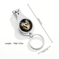 Close-up of a silver 3-in-1 multi-functional nail clipper keychain with golden letter S - Letter S