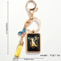 Keyring with gold letter K pendant, colorful butterfly charm and yellow fringe detail - Letter K
