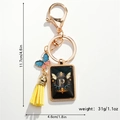 Close-up of golden letter P keychain with butterfly pendant and yellow leather tassel - Letter P