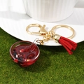 Detail van miniatuur voedsel sleutelhanger met rode kwastjes en gouden metalen ring - Acht Schatten Pap