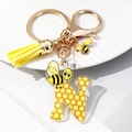 Detail of letter N keychain with acrylic honeycomb pattern, yellow tassel and enamel bee charm - Letter N