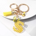 Macro detail of acrylic letter S keychain with honeycomb pattern and yellow leather tassel - S