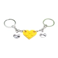 Close-up of interlocking yellow heart brick keychains with engraved pinky promise charms - Yellow