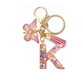 Detail showing resin letter K keychain with pink heart sequins, butterfly charm and tassel - Letter K