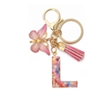 Close-up of resin letter L keychain with pink heart sequins, butterfly and tassel - Letter L