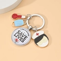 Detailed medical keychain with thermometer, blue mask, and nurse charms on round stand - Thermometer Mask Tag Combination (5)