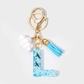 Macro detail of sky-themed resin letter L keychain with blue clouds and black birds - Letter L Style (L)