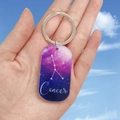 Détail d'un porte-clés Cancer en acrylique avec design ciel étoilé violet et anneau métal - Cancer