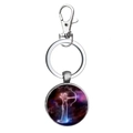 Detail of silver metal zodiac keychain with Sagittarius glass dome on white background - Sagittarius
