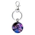 Detail of metal Gemini constellation keychain featuring a celestial star art glass dome - Gemini