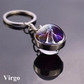 Macro shot of Virgo zodiac glass ball keychain with starry constellation on black surface - Virgo (8)