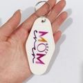 Close-up of hand holding a white vintage motel key tag with colorful Best Mom Ever text - Purple Gradient Best Mom Ever (4)