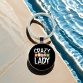 Detail of round Bingo game keychain with Crazy Lady text on natural stone surface - Crazy Bingo Lady(3)
