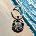 Macro detail of silver bingo ball keychain featuring printed fun quote on stone background - Give Those Balls A Good Shake(13)