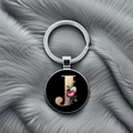 Macro shot of letter J keychain with floral pattern on a grey plush background - Letter J