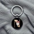 Detailed view of metal keychain with letter N and floral design on grey fur background - Letter N