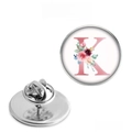 Detailed view of round metal badge with floral letter K design and butterfly clutch back - Letter K