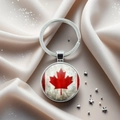 Detailed close-up of a silver Canada flag keychain resting on elegant beige silk fabric - Vintage Distressed Maple Leaf Style (2)