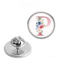 Macro view of stainless steel round brooch showing letter P and floral pattern detail - Letter P