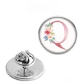 Macro detail of silver stainless steel brooch back with pin and floral letter Q design - Letter Q