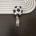 Detailed close-up of a retractable soccer ball badge holder with clear plastic clip - Football Pattern (1)