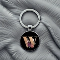 Detailed close-up of floral letter W keychain on elegant grey faux fur background - Letter W