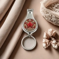 Detailed view of silver Canada flag nail clipper keychain with red maple leaf on lace fabric - Style 6