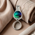 Detailed close-up of nail clipper keychain with colorful aurora glass on silk background - Green-Blue-Purple Gradient Aurora