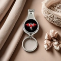 Close-up of metal nail clipper keychain with Canada maple leaf on silk and lace background - Style 13