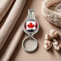 Close-up of metal nail clipper keychain with Canada flag design on fabric background - Style 15
