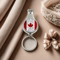 Detail of Canadian flag nail clipper and keychain on soft silk background - Style 20