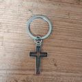 Minimalistische zilveren holle kruis hanger sleutelhanger op houten ondergrond - Zilveren Hol Kruis