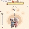 Detalle del llavero acrílico 2D con gatos abrazados y grosor de material de 0,25cm - Estilo Gatos abrazados con suéteres azul y rosa (1)