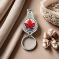 Silver metal nail clipper keychain with red maple leaf design on silk background - Style 9