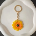 Portachiavi girasole con petali gialli sfumati posizionato su un piatto decorativo bianco - Accessori Oro