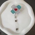 Close-up of heart patterned bandage style retractable badge holder with metal clip - Red Heart Crossed Band-aid Style (3)