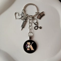 Macro detail of silver medical keychain with stethoscope, heart and letter K charms - Letter K