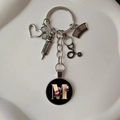 Detail view of medical keychain with heart, stethoscope charms and letter M floral disc - M